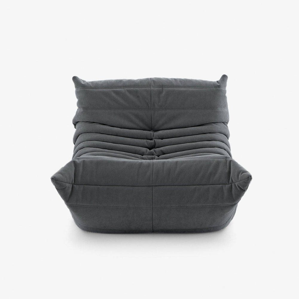 #Gris Koto Mini chauffeuse lounge compressée 1 place coloris gris, vue trois quarts : fauteuil bas au design 70s, assise ferme, velours matelassé, livré compressé