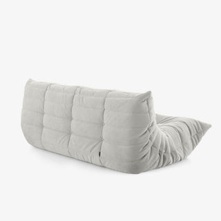 #Blanc Koto canapé lounge compressé 3 places coloris blanc, mise en situation dans un salon : assise ferme, silhouette années 70, velours matelassé, livré compressé dans un seul carton